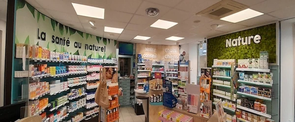 L'image représente un magasin intérieur nommé « Nature La santé au naturel ». Les étagères sont remplies de produits variés, créant une collection qui suggère une approche axée sur la santé naturelle et la commodité. L'aménagement comprend des bibliothèques et des présentoirs le long des murs, soulignant l'agencement du magasin dans un espace défini par un plafond et un sol.