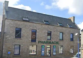 L'image représente un bâtiment doté de multiples fenêtres et enseignes. L'enseigne bien visible indique qu'il s'agit d'une pharmacie (PHARMACIE). Autour du bâtiment, des éléments tels que des nuages dans le ciel soulignent le cadre extérieur, tandis que la maçonnerie contribue à son attrait immobilier. L'établissement semble s'intégrer dans un paysage urbain